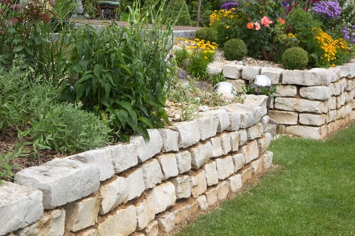 Blumenbeet mit Trockenmauer abgestützt